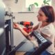 Woman working on a new kitchen installation and using a cordless drill