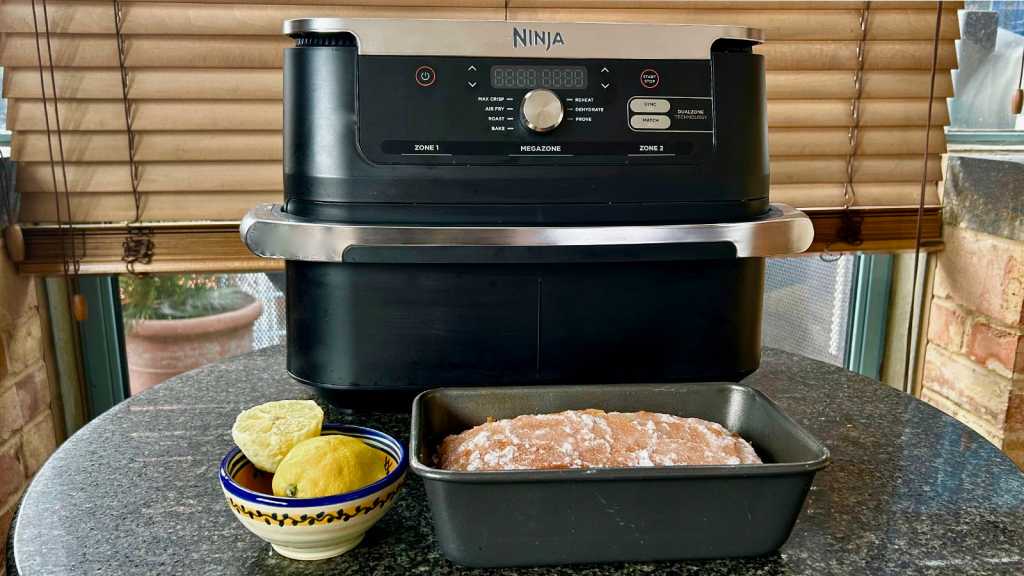 Ninja air fryer with a loaf cake in a tine in front of it