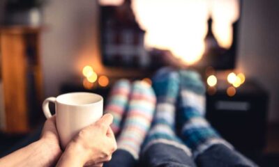 Two people in cosy socks watching TV with a cup of coffee