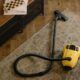 Yellow canister vacuum on a rug