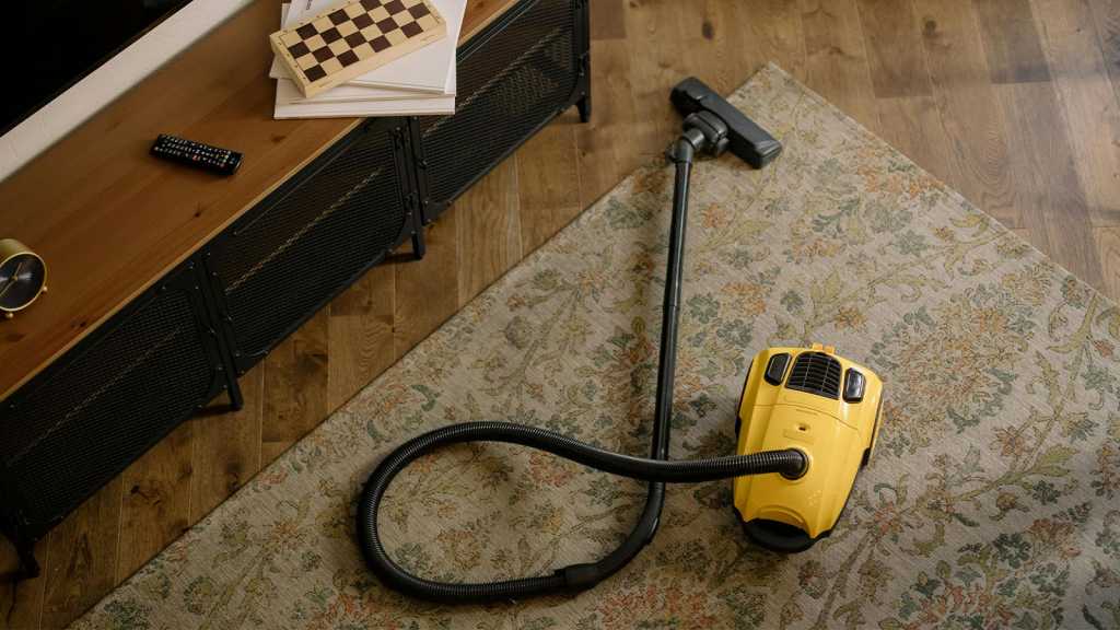 Yellow canister vacuum on a rug