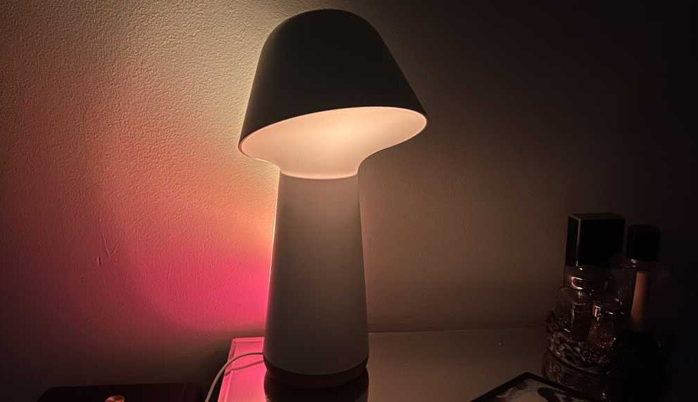 The lamp casting coloured light on the wall behind it