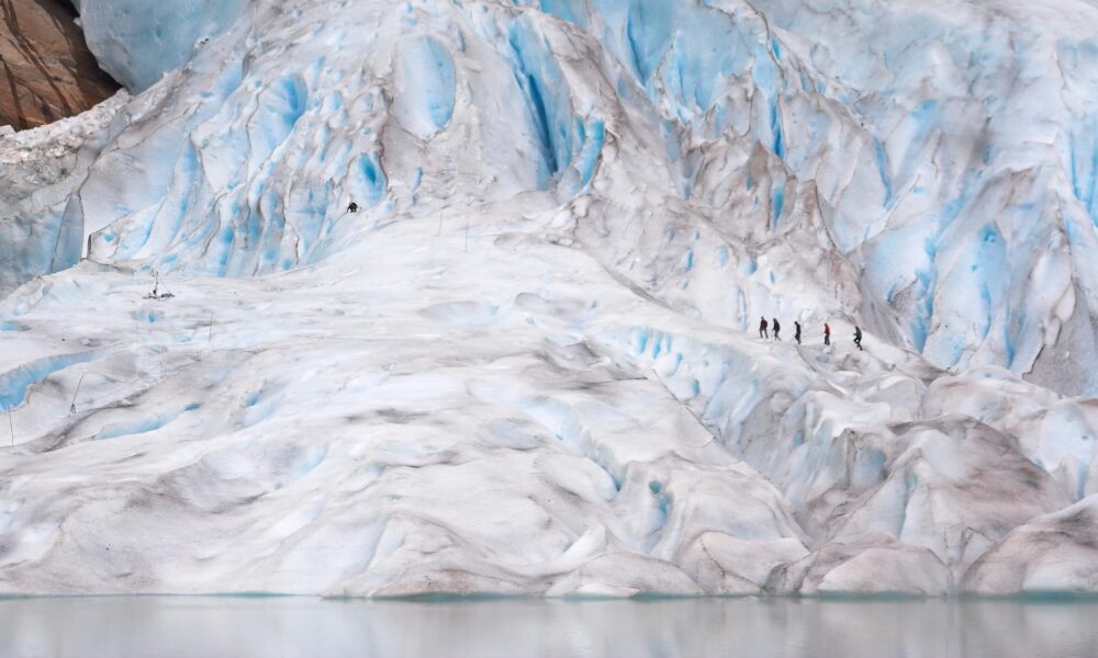 a group of people walking on a large glacier