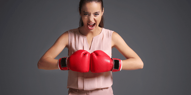 Determination makes you work hard and become relentless. A woman showing her determination in boxing 