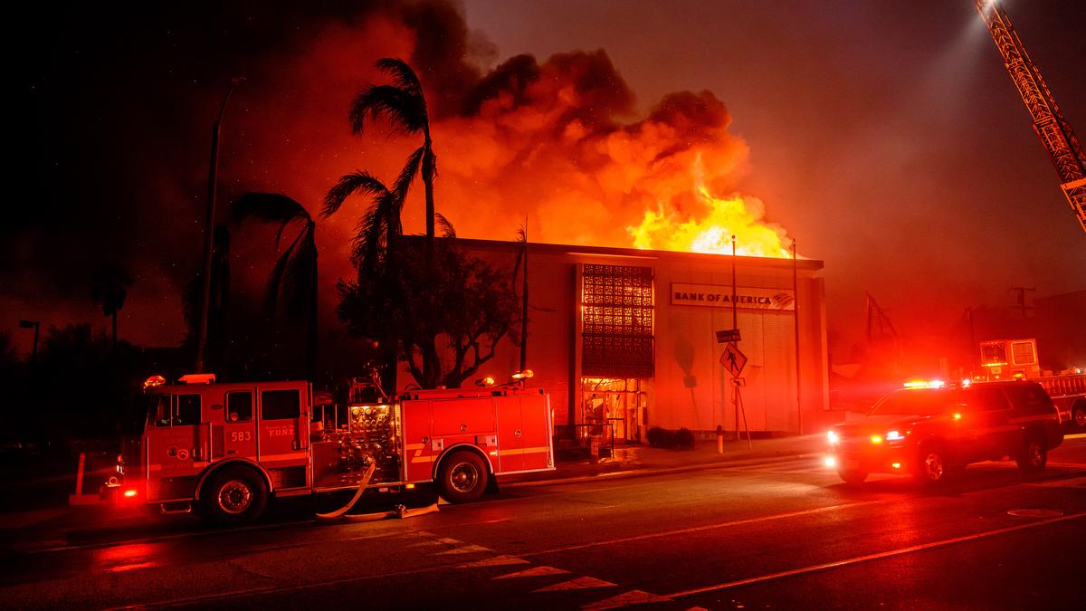 Firefighters battle devastating Los Angeles wildfires as winds calm somewhat