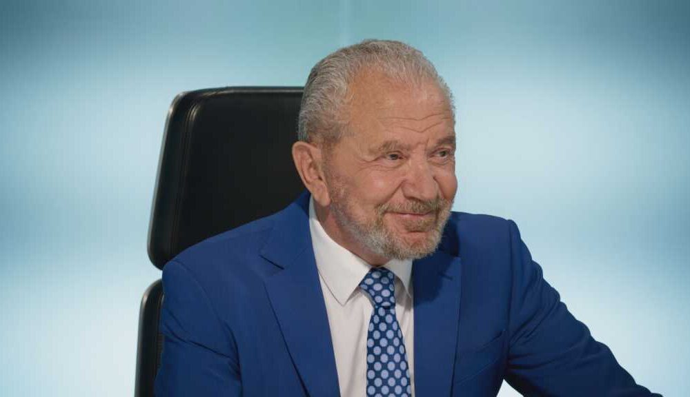 Lord Sugar smiling in the boardroom