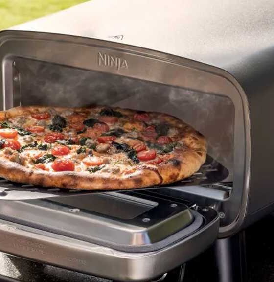 Pizza being removed from the Artisan oven