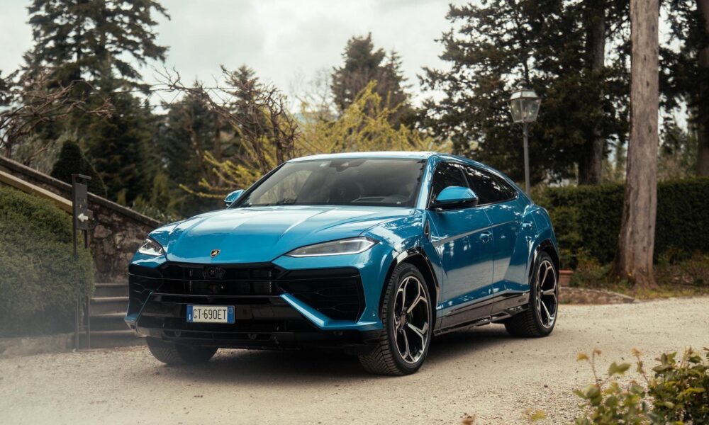 a blue sports car parked in front of rock wall