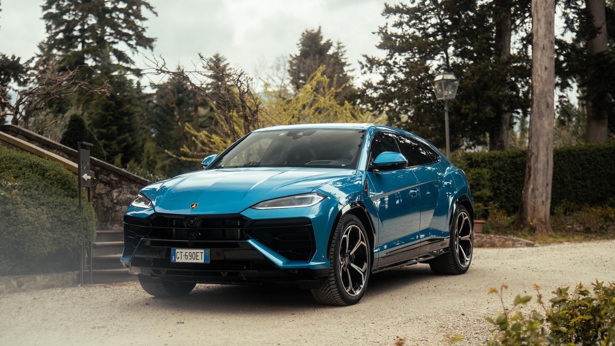 a blue sports car parked in front of rock wall