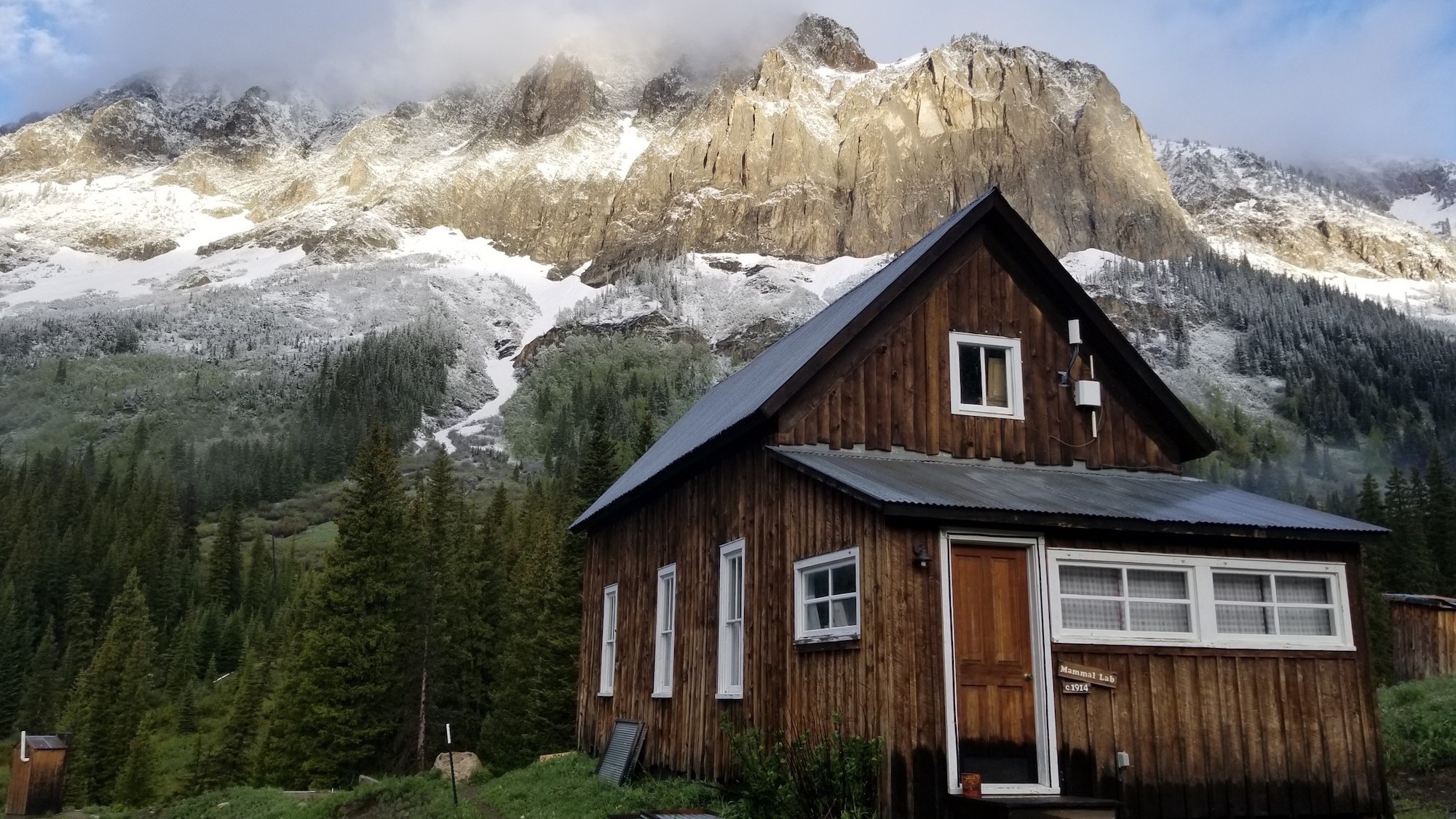 a brown building against mountain backdrop